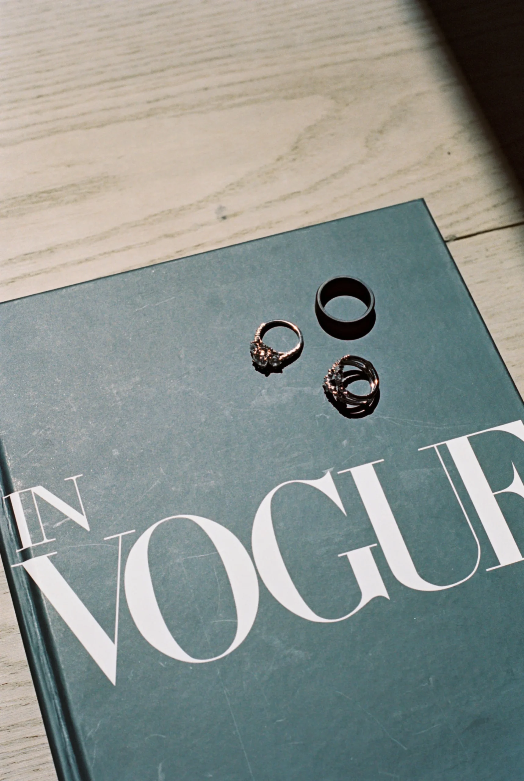 Rings on a Vogue magazine cover on a wooden surface.