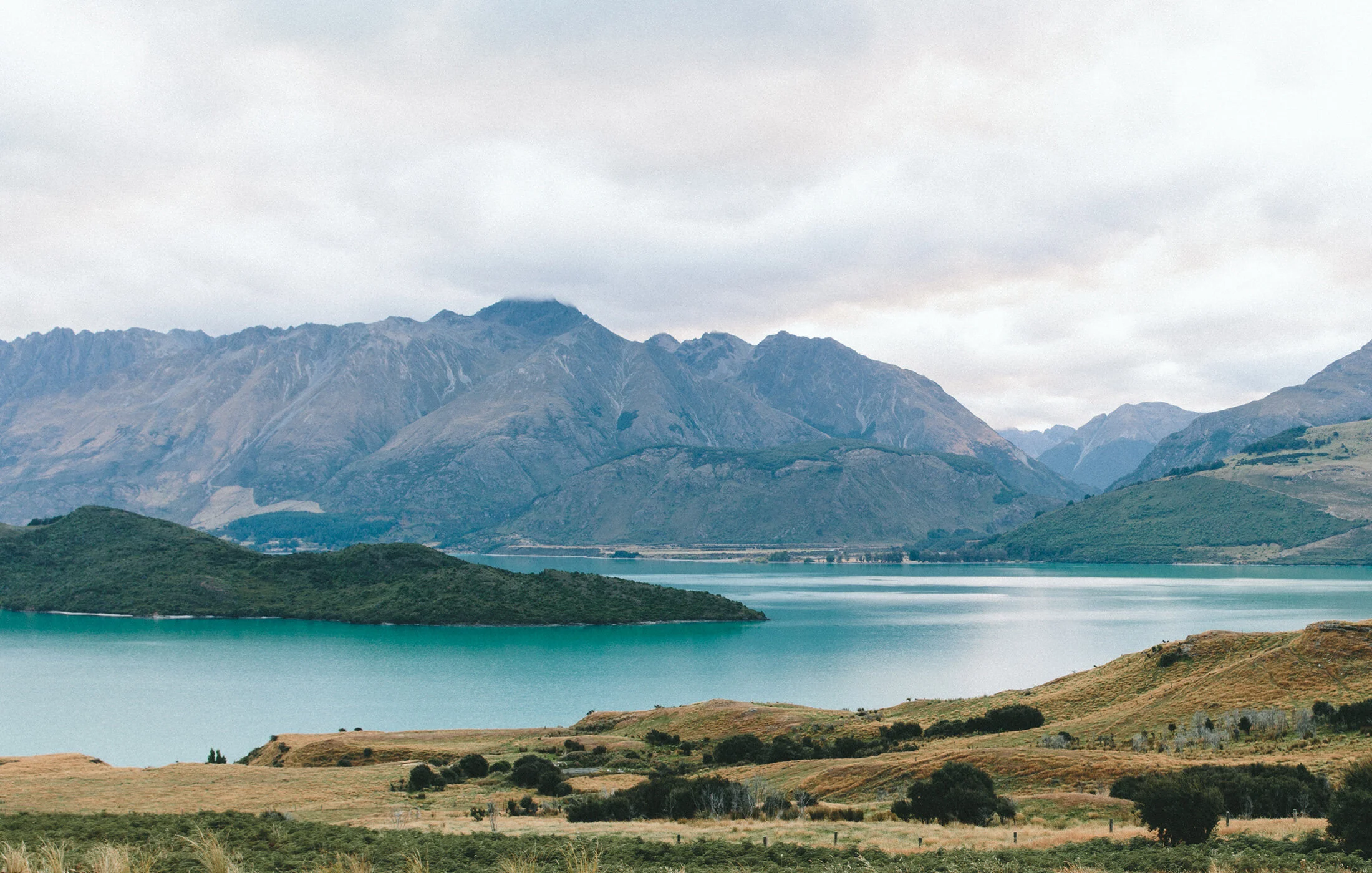 Serene lake surrounded by mountains and rolling hills