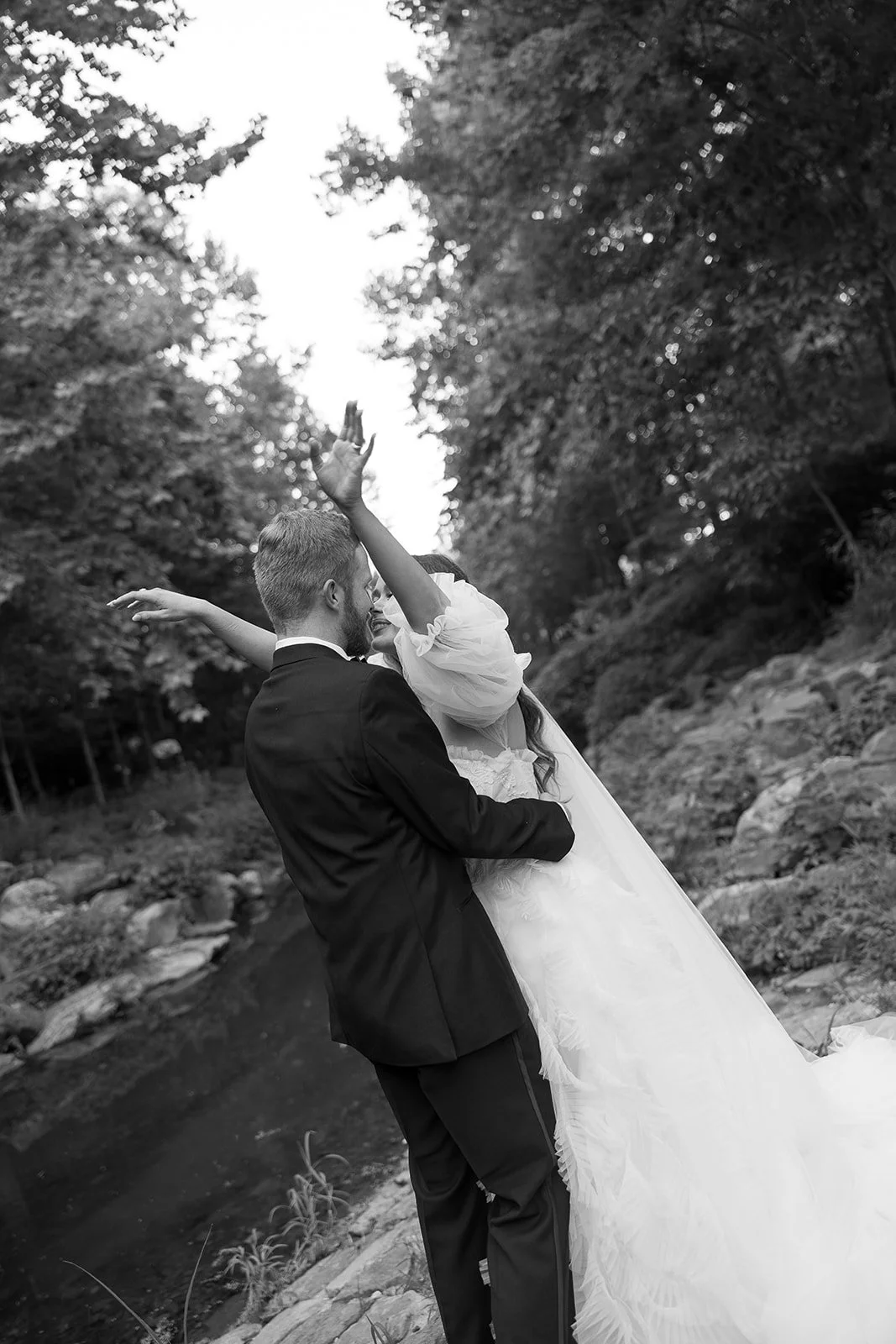 Wedding photography of bride and groom falling into a hug together during their wedding day natural candid photography by Laura Powers Photo