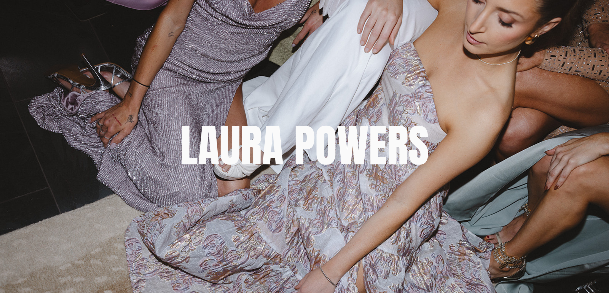 Close-up of people sitting in elegant dresses, visible from shoulders to knees, with "LAURA POWERS" text overlay.