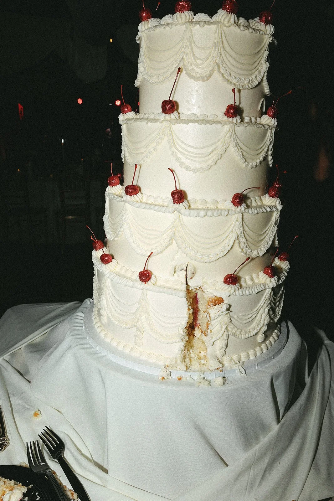four layered beautiful trendy wedding cake with cherries at wedding reception, flash photography by Laura Powers Photo