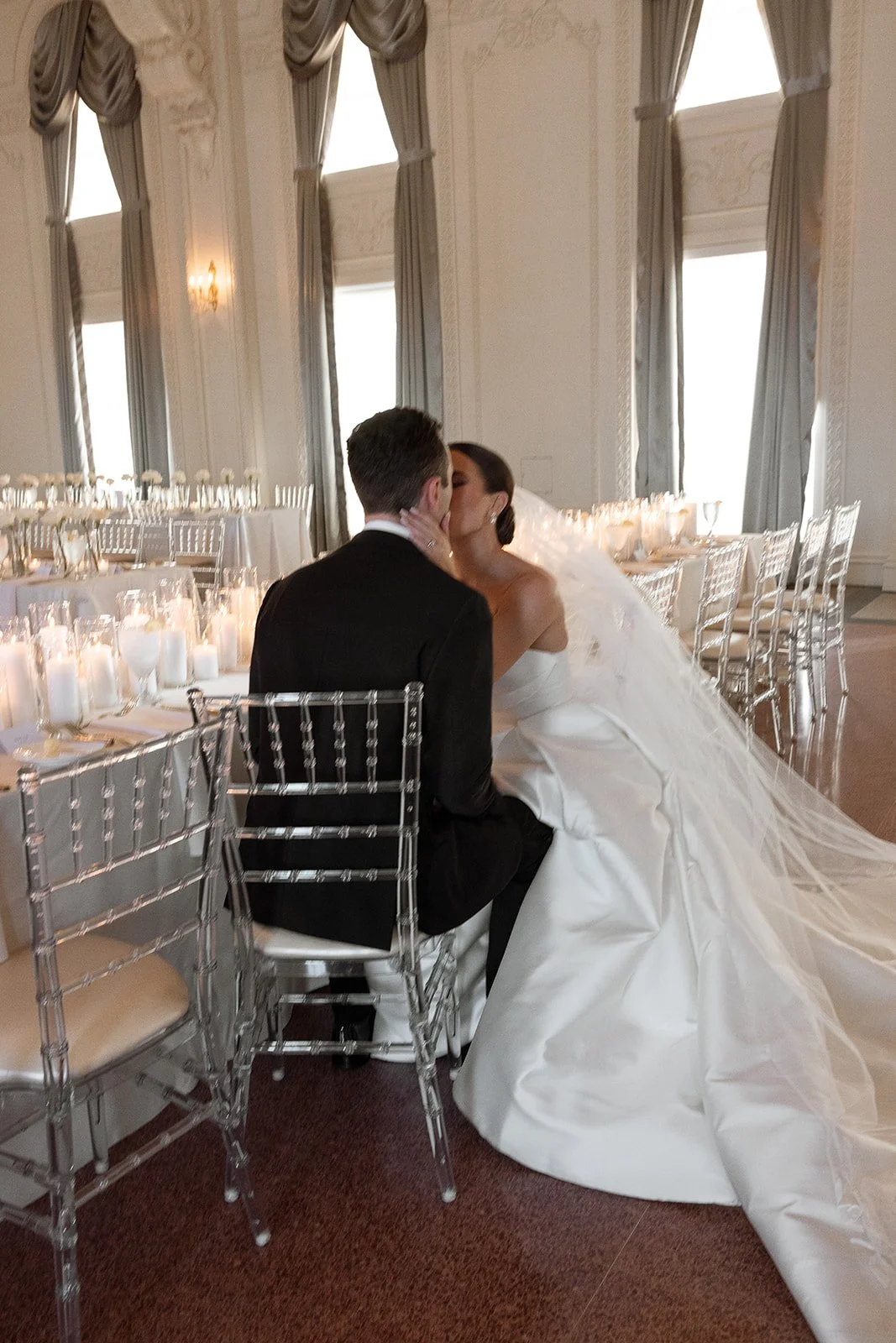 Bride and Groom at beautiful candle lit reception kissing before their reception starts. 