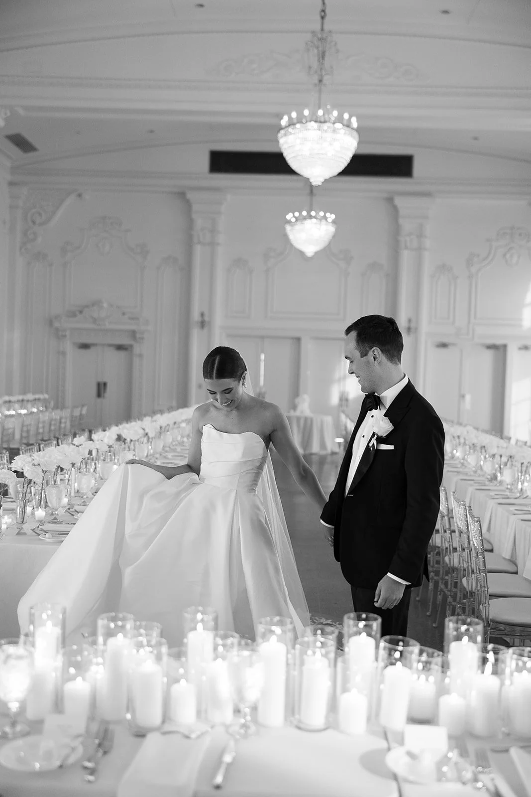 Bride and Groom walking through their beautiful candle lit reception space at the Mayo Hotel in Oklahoma by Laura Powers Photo