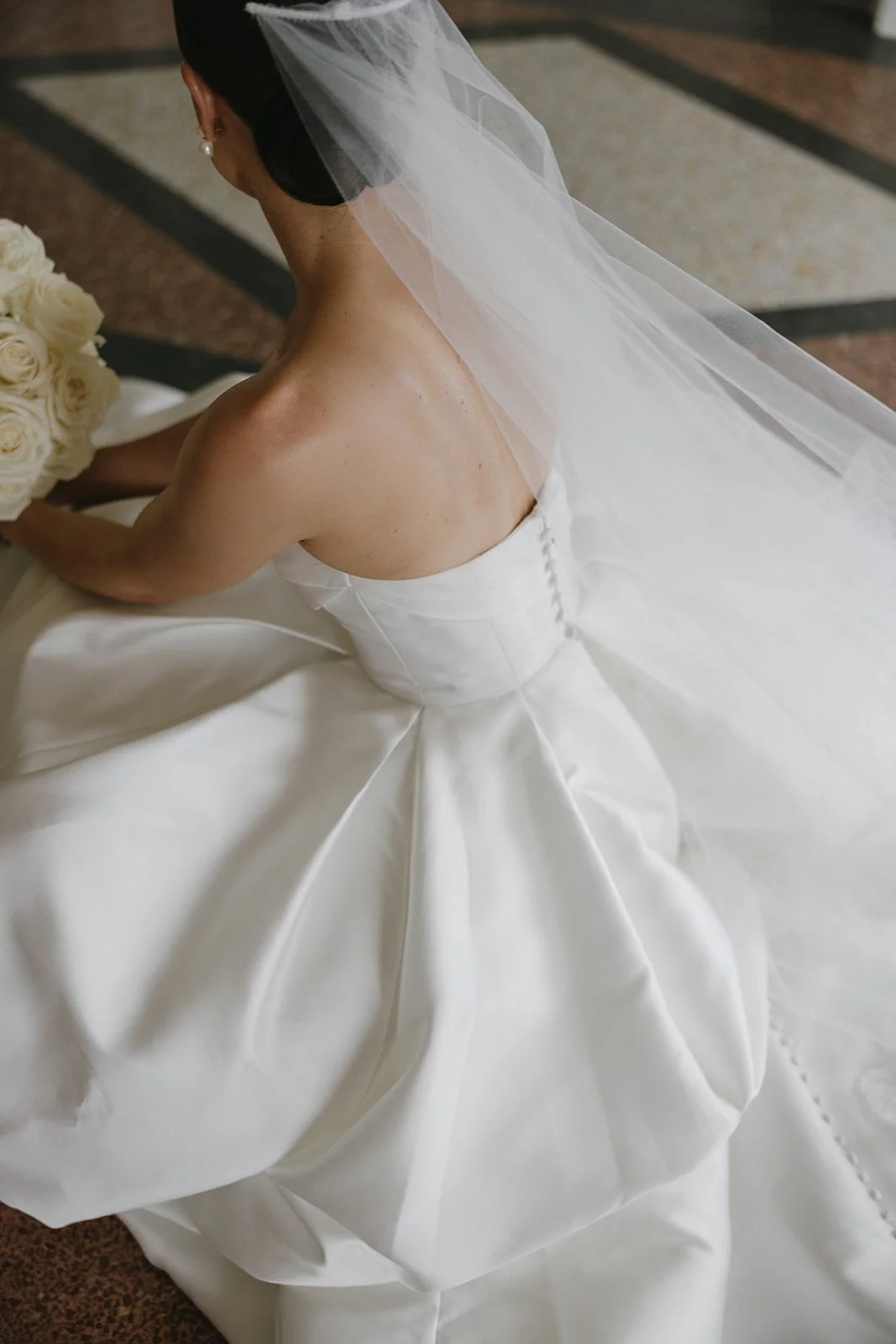 Beautiful timeless chic photo of the back of brides wedding dress and veil